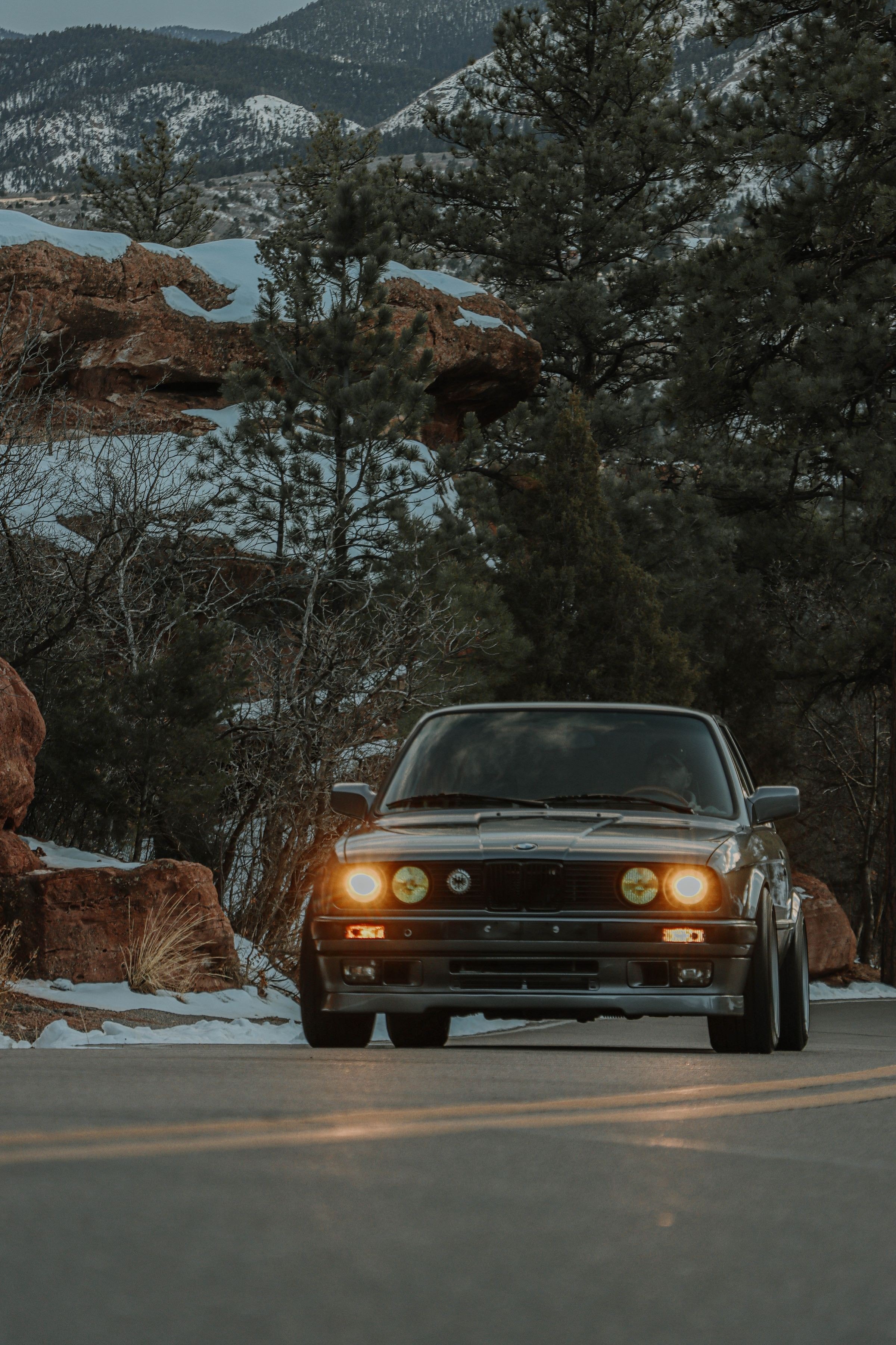 Automobile ancienne sur une route de montagne enneigée au crépuscule